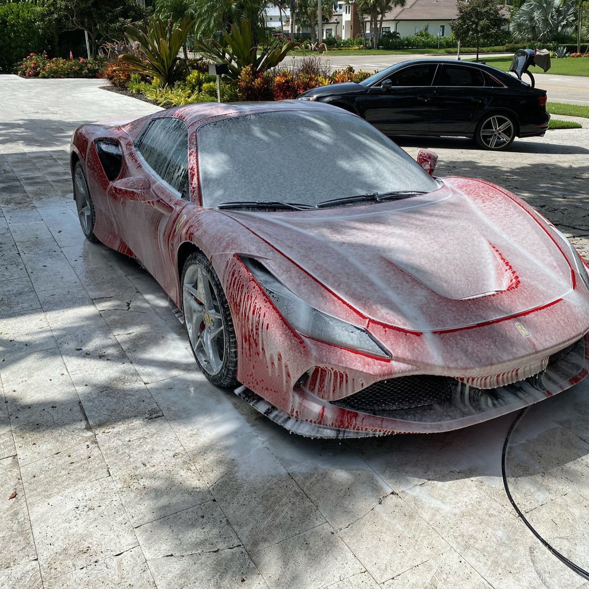 Ferrari F8 Spider covered in snow foam during a mobile wash in Naples, Florida