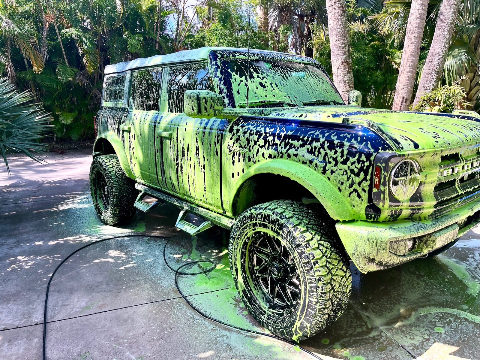 Ford Bronco under contactless snow foam pre-wash in a Naples driveway