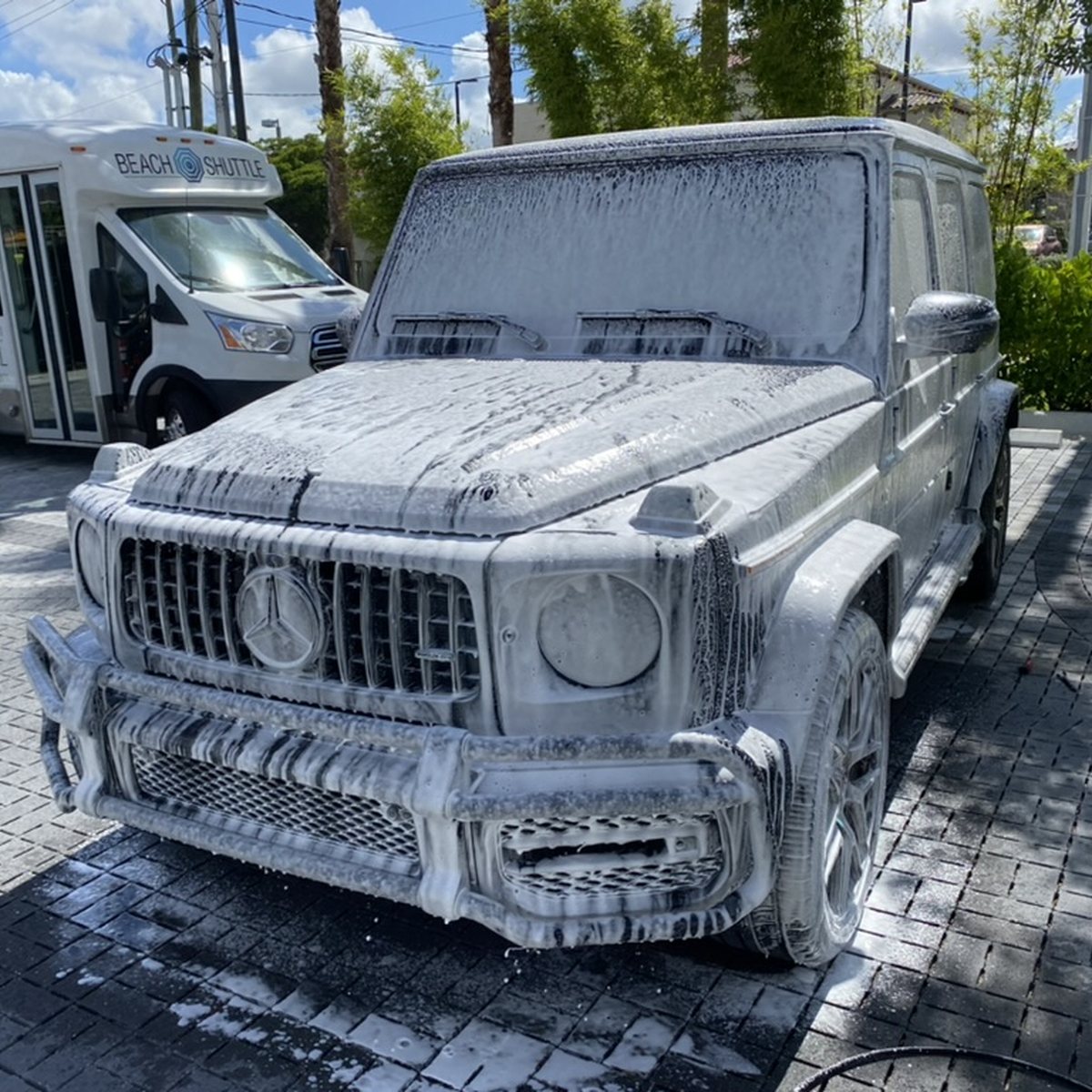 Matte black Mercedes-AMG G63 covered in snow foam during a mobile wash in Naples, Florida