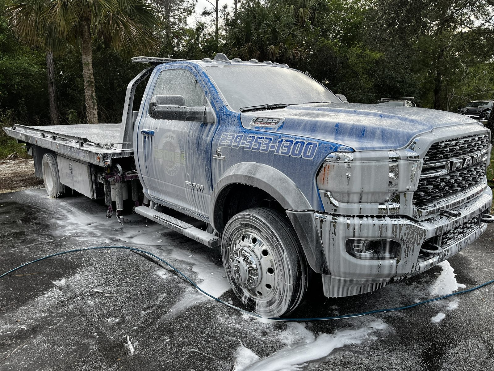 Flatbed tow truck being foamed at the yard where it is parked